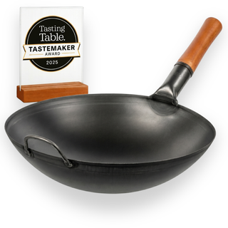 Black wok with wooden handle and Tasting Table Tastemaker Award on a white background